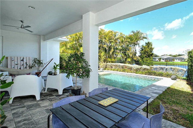 view of patio with ceiling fan, fence, and a fenced in pool