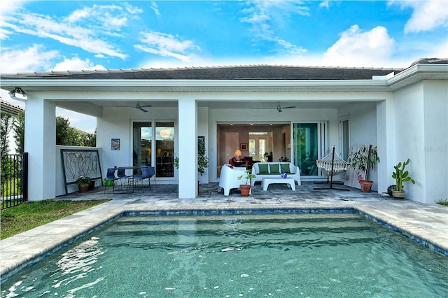 rear view of house featuring a patio area, a ceiling fan, and an outdoor pool