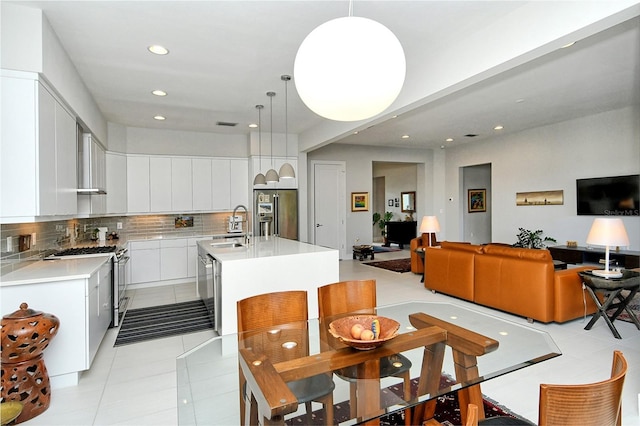 kitchen featuring stainless steel appliances, white cabinets, light countertops, tasteful backsplash, and modern cabinets