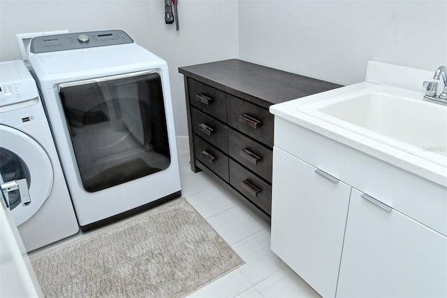 laundry room featuring separate washer and dryer, light tile patterned flooring, a sink, and cabinet space