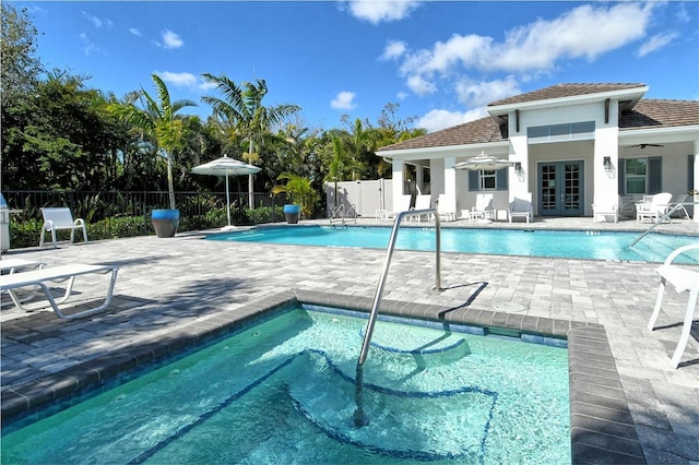 pool with french doors, a patio area, fence, and an outdoor structure