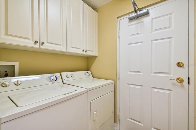 washroom featuring cabinet space and separate washer and dryer