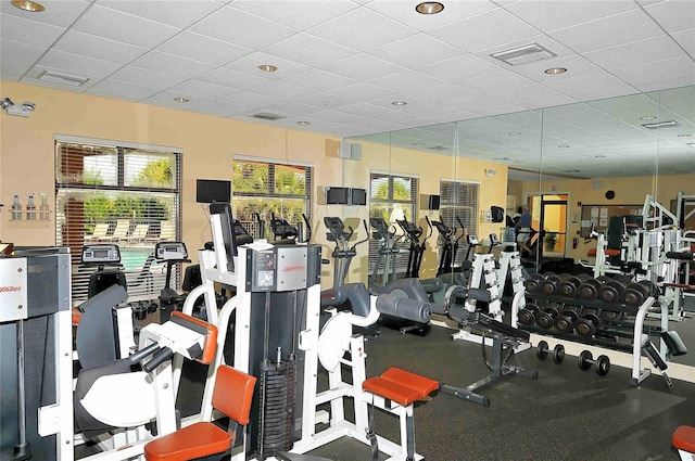 exercise room with visible vents and a paneled ceiling