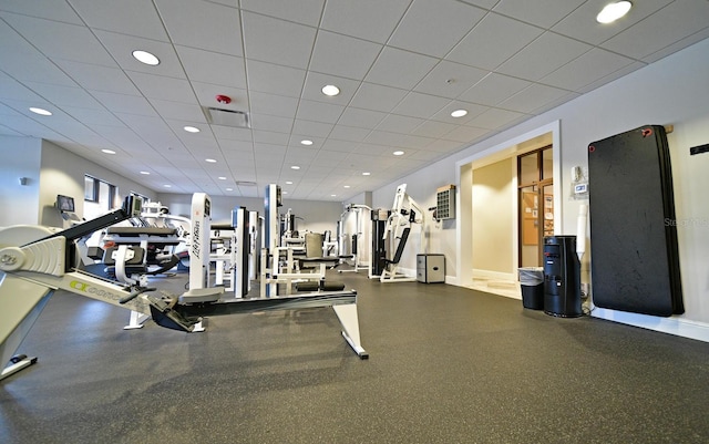 gym featuring recessed lighting, baseboards, and a paneled ceiling