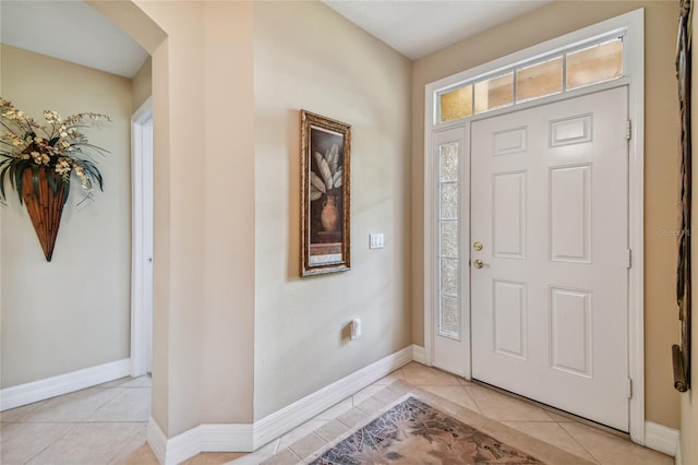 foyer entrance with light tile patterned floors and baseboards