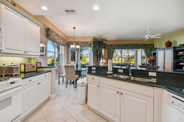 kitchen with visible vents, a sink, light tile patterned flooring, range, and hanging light fixtures