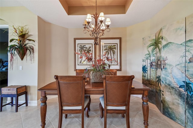 dining area featuring a chandelier, light tile patterned floors, a raised ceiling, and baseboards