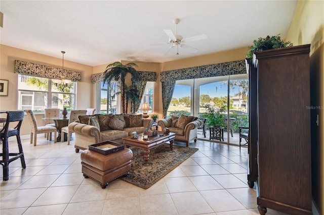 living area featuring light tile patterned flooring and ceiling fan with notable chandelier