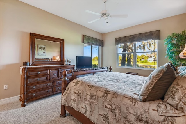 carpeted bedroom with ceiling fan and baseboards