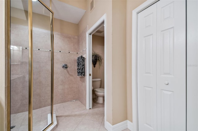 bathroom featuring baseboards, tile patterned flooring, a shower stall, a closet, and toilet