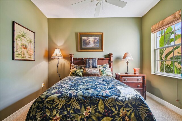 carpeted bedroom featuring baseboards and ceiling fan