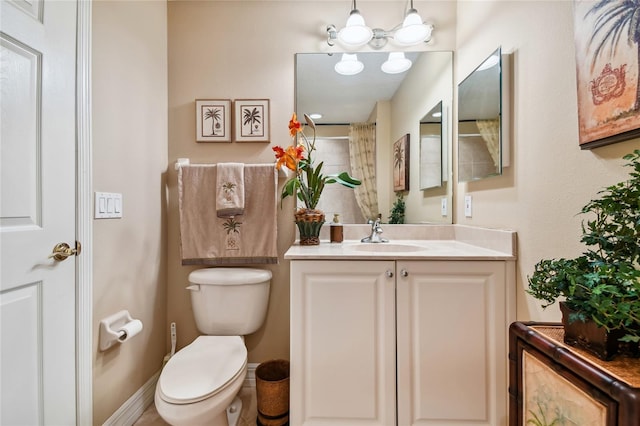 bathroom with toilet, vanity, and walk in shower