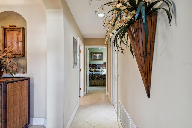 hall with light tile patterned flooring, baseboards, and visible vents