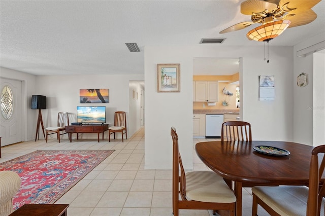 dining space featuring a textured ceiling, ceiling fan, light tile patterned flooring, and visible vents