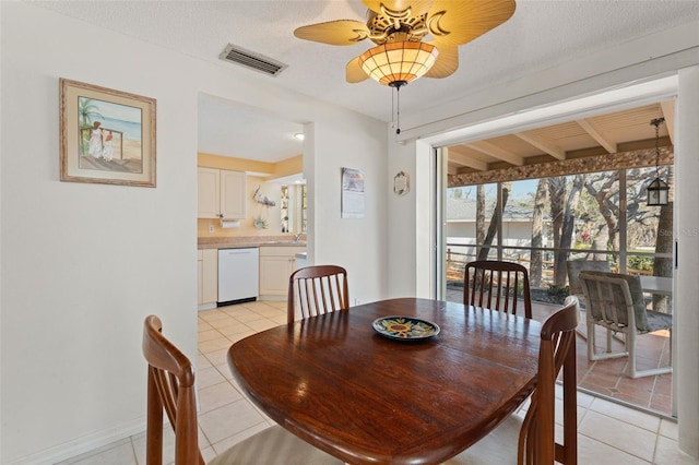 dining room with a ceiling fan, visible vents, a textured ceiling, and light tile patterned floors