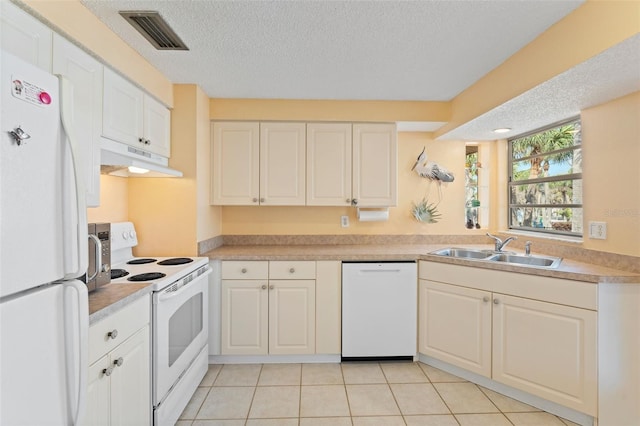 kitchen featuring visible vents, a sink, a textured ceiling, white appliances, and under cabinet range hood