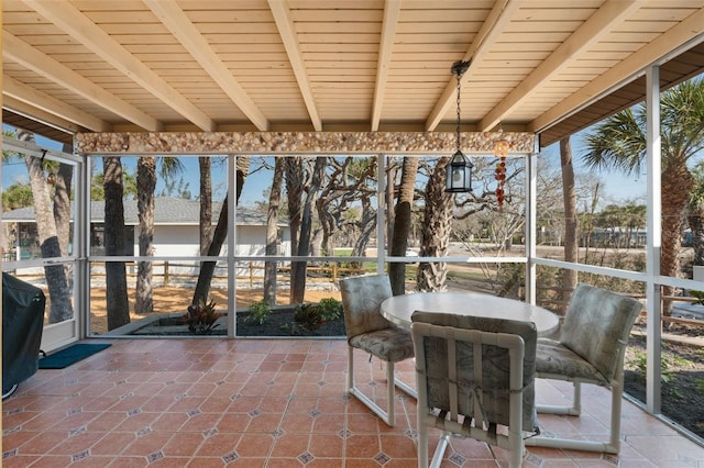 unfurnished sunroom with beamed ceiling