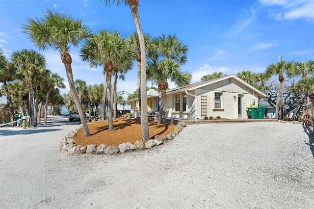 view of front facade with gravel driveway and stucco siding