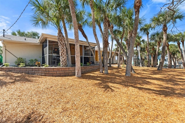 exterior space with a sunroom and stucco siding