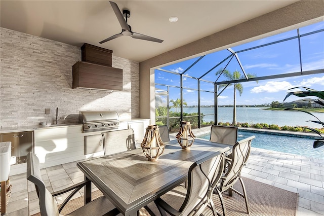 view of patio featuring a water view, grilling area, an outdoor kitchen, outdoor dining space, and a lanai