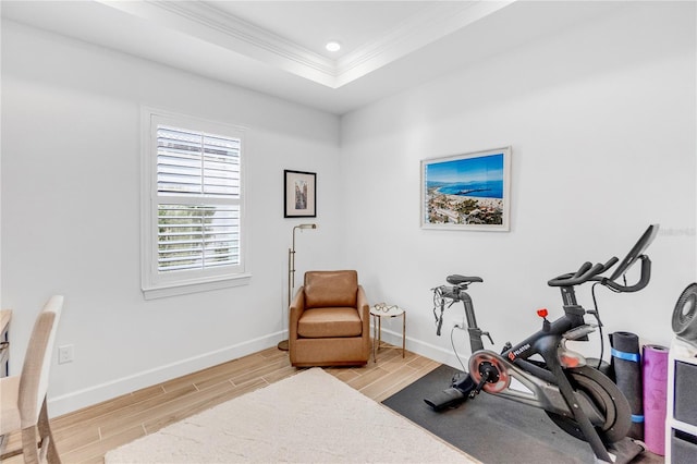 workout room with wood finish floors, a tray ceiling, recessed lighting, ornamental molding, and baseboards