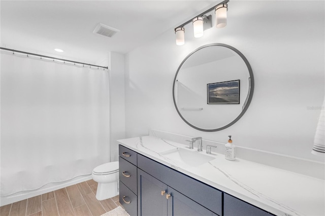 bathroom featuring toilet, wood finish floors, vanity, visible vents, and shower / bath combo with shower curtain