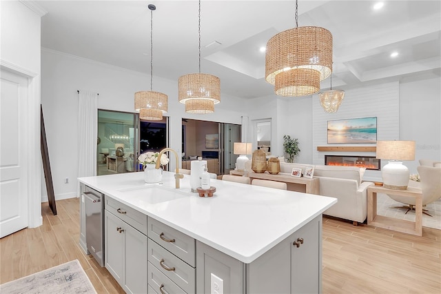 kitchen featuring gray cabinets, a sink, light wood finished floors, and open floor plan