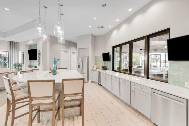 kitchen with appliances with stainless steel finishes, light countertops, visible vents, and decorative backsplash