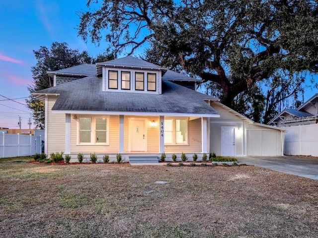 view of front of property featuring covered porch, fence, and a front lawn