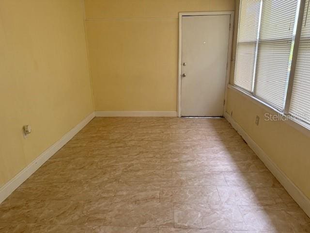 unfurnished room featuring baseboards