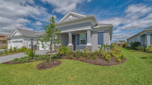 view of front of house with an attached garage, stone siding, decorative driveway, stucco siding, and a front yard