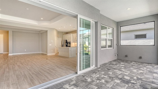 spare room with light wood-style floors, recessed lighting, baseboards, and a textured wall