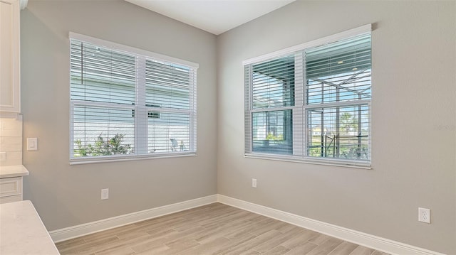 empty room with light wood-type flooring and baseboards