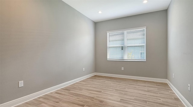 unfurnished room with recessed lighting, light wood-type flooring, and baseboards