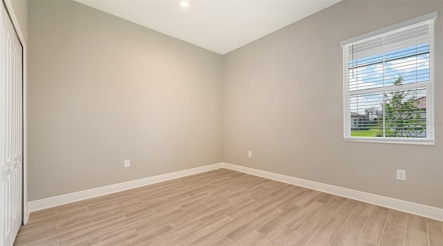 empty room with light wood-style flooring and baseboards