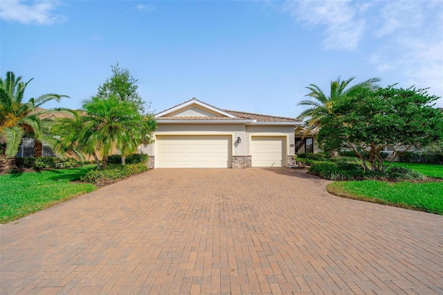 8007 River Preserve Dr, Bradenton, FL 34212 - view of front facade with stone siding, decorative driveway, an attached garage, and stucco siding