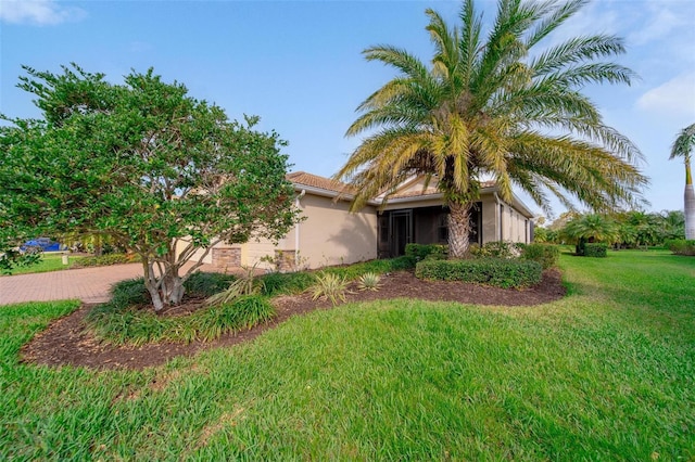 view of front of home with a front lawn, decorative driveway, an attached garage, and stucco siding