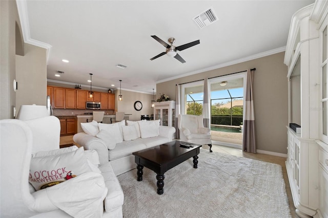 living room with ornamental molding, recessed lighting, visible vents, and baseboards