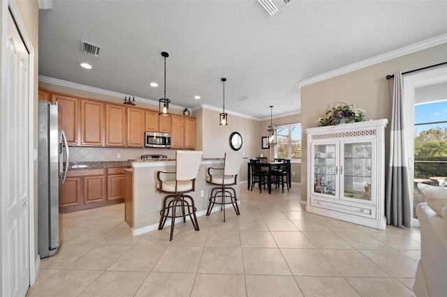 kitchen featuring light tile patterned floors, appliances with stainless steel finishes, a kitchen bar, and visible vents