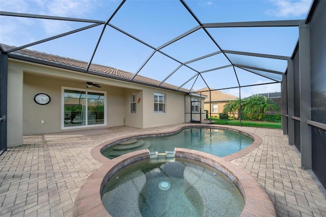 view of pool featuring a patio, a pool with connected hot tub, a lanai, and a ceiling fan