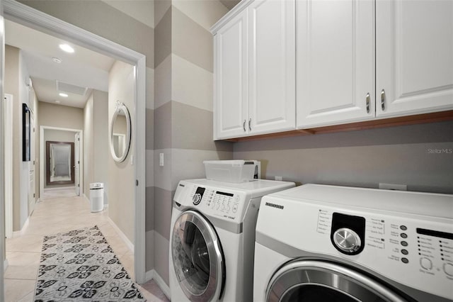 washroom featuring light tile patterned flooring, recessed lighting, baseboards, cabinet space, and washer and clothes dryer