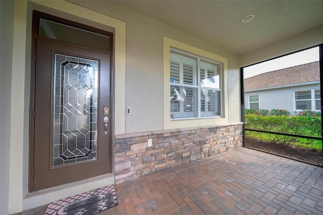 entrance to property with stone siding and stucco siding