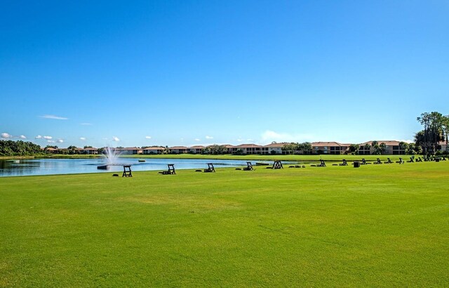 view of community with a water view and a yard