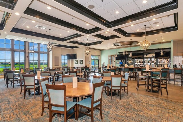 dining space featuring a chandelier, a high ceiling, coffered ceiling, visible vents, and beam ceiling