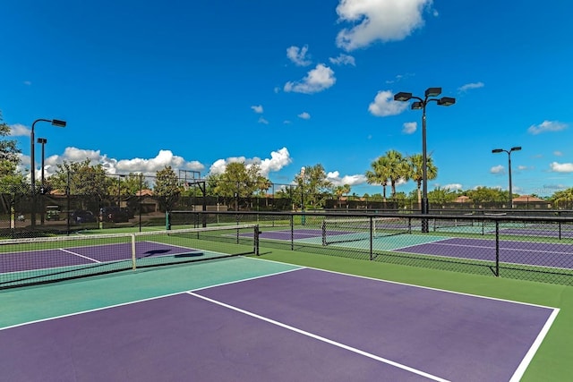 view of tennis court with community basketball court and fence