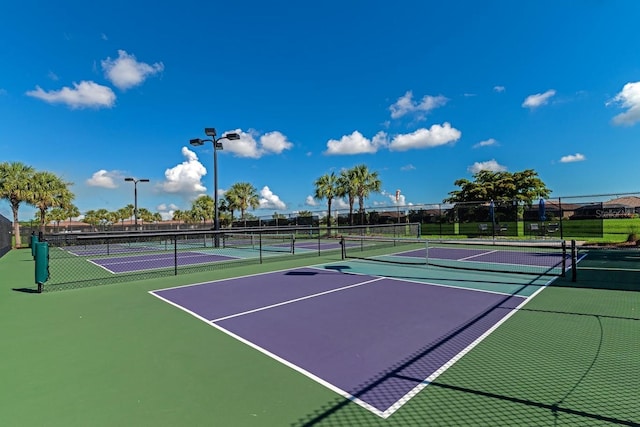 view of tennis court featuring community basketball court and fence