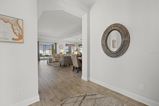 hall with baseboards and wood finished floors