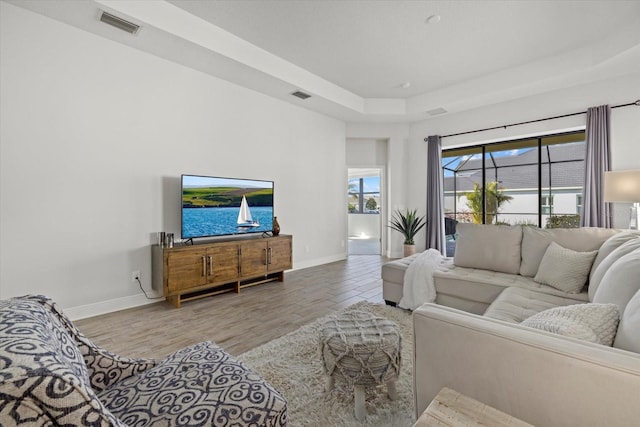 living room with visible vents, baseboards, and wood finished floors