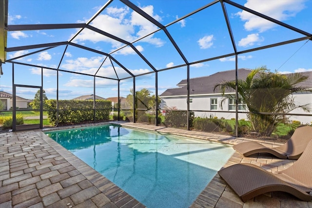 outdoor pool featuring glass enclosure and a patio