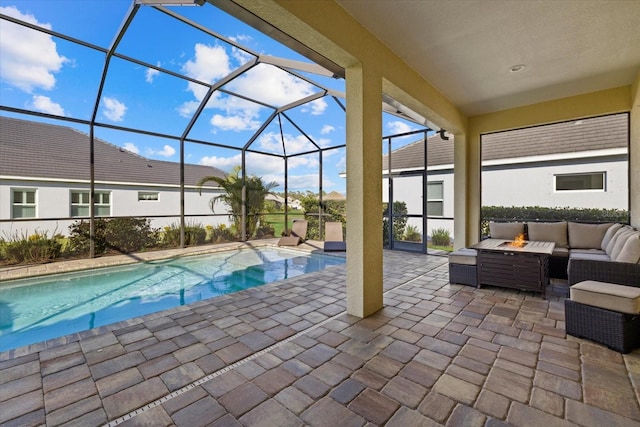 outdoor pool featuring glass enclosure, outdoor lounge area, and a patio